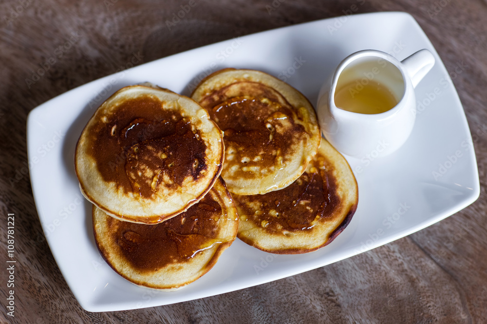 Delicious homemade pancakes with honey on a white plate Delicious homemade pancakes with honey on a white plate