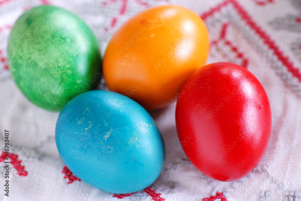 Four colorful easter eggs on linen tablecloth Four colorful easter eggs on linen tablecloth