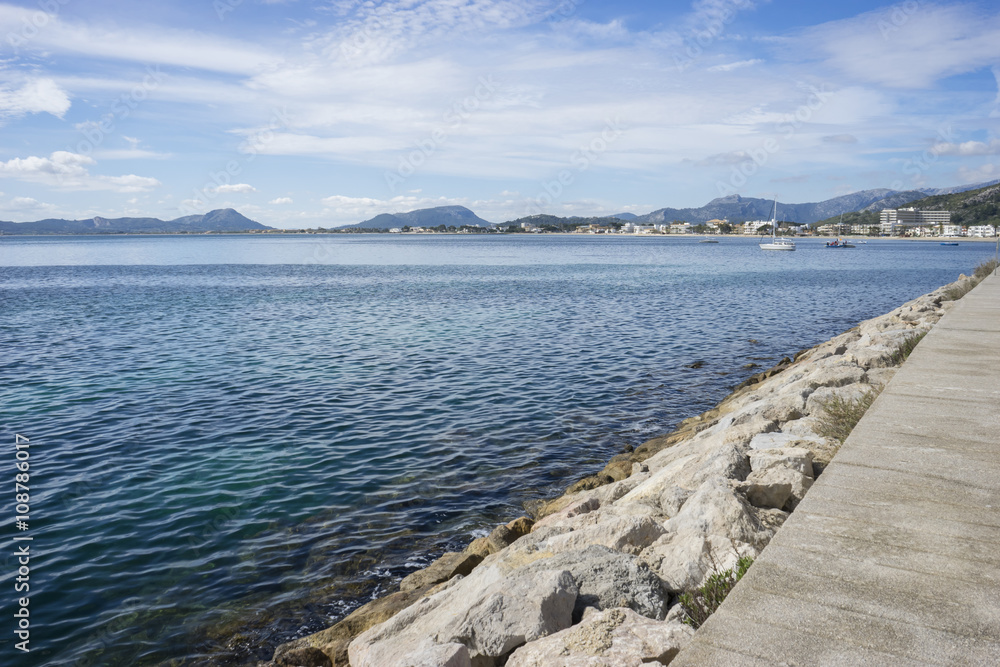 Obraz premium promenade with calm sea and small lighthouse