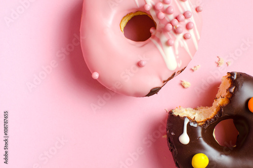 Fototapeta Naklejka Na Ścianę i Meble -  Donuts with icing on pink background. Sweet donuts. Donuts background . Eaten donut.