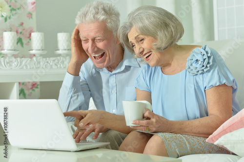 happy senior couple with laptop