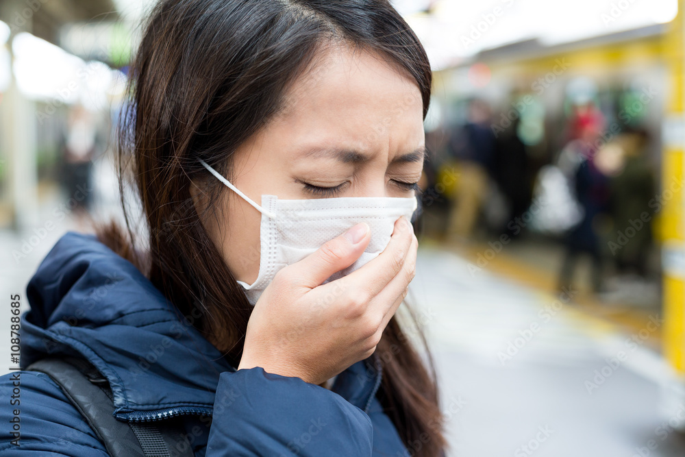 Asian woman wearing face mask at train station Asian woman wearing face mask at train station