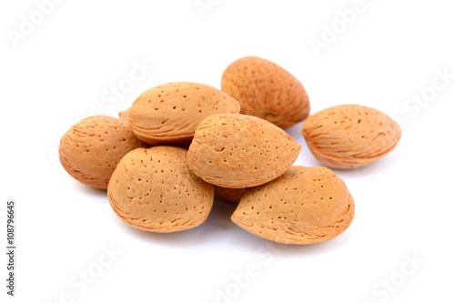 Pile of unpeeled almonds isolated on white background