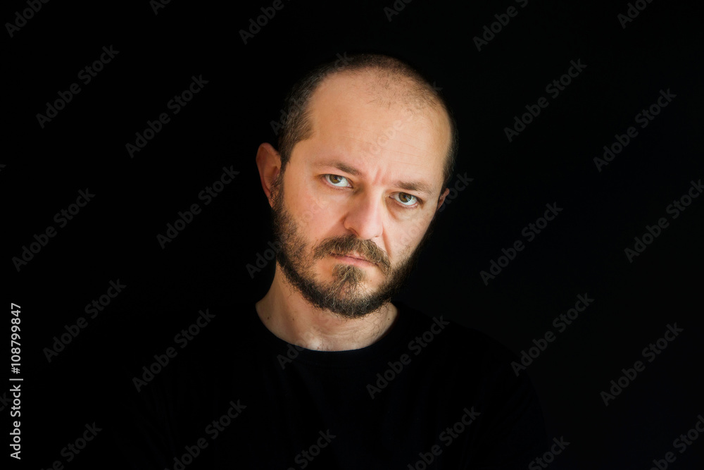 Handsome man with beard and mustaches wearing black shirt on black background Handsome man with beard and mustaches wearing black shirt on black background