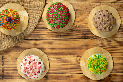 Multicolored cupcakes on wooden table