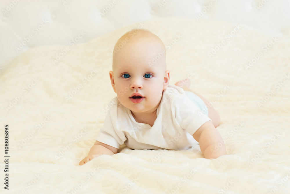 Portrait of little baby crawls on the bed at home Portrait of little baby crawls on the bed at home