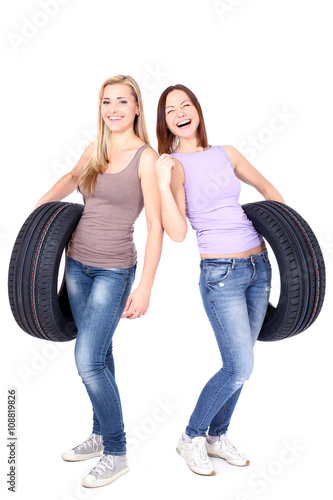 Tire. Two women holding car wheels