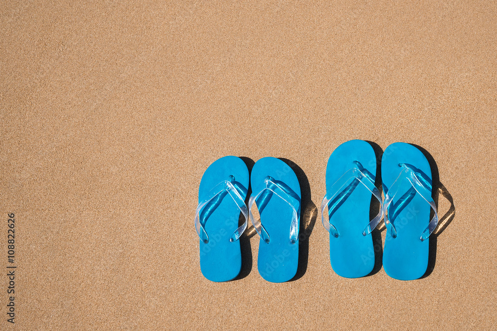Naklejka premium flip flops on a sand