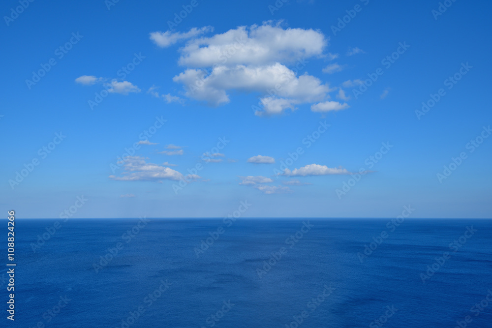 Vast deep blue sea with white clouds