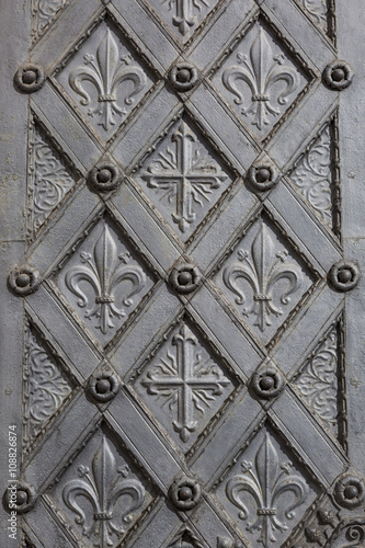 Metal ornamental door with cross and fleur de lis