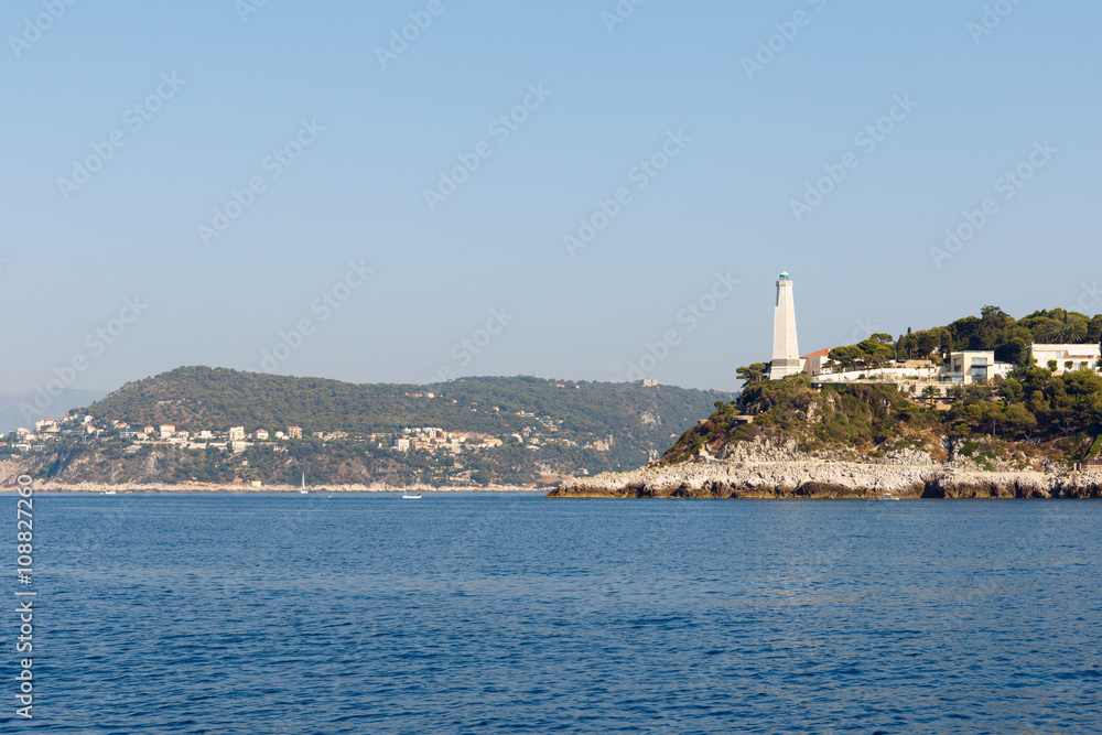 Color DSLR wide angle stock image of lighthouse and houses along the Mediterranean coast of the French Riviera near Nice, France. Horizontal with copy space for text
