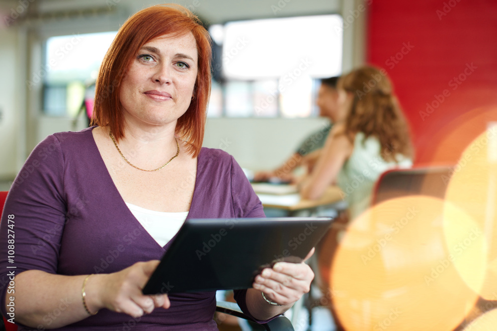 Confident female designer working on a digital tablet in red creative office space Confident female designer working on a digital tablet in red creative office space