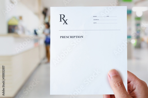 hand hold prescription paper with hospital background