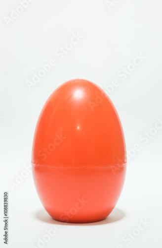 Red plastic egg on white table