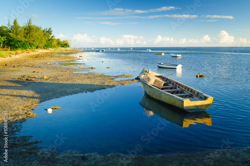 Fototapeta Naklejka Na Ścianę i Meble -  Fishing boats on the background of incredible golden sunset. Mauritius Island