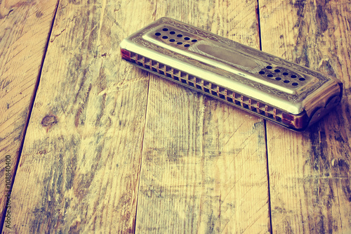 vintage harmonica lying on table photo