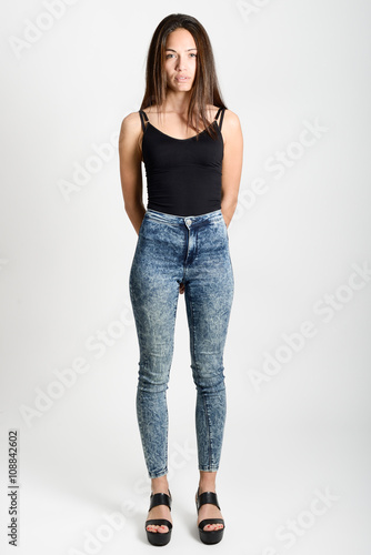 Young woman wearing black tank top and blue jeans