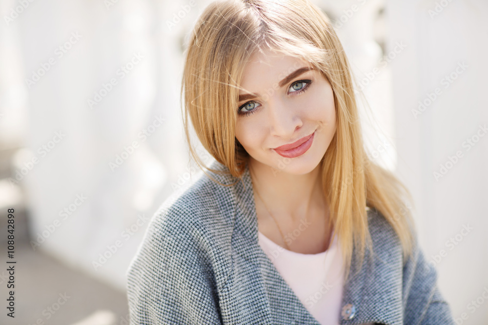 Beautiful woman with long blonde straight hair and grey eyes,light makeup,dressed in a pink shirt and gray blazer,spends time alone on a city street,posing for the photographer,smiling sweetly Beautiful woman with long blonde straight hair and grey eyes,light makeup,dressed in a pink shirt and gray blazer,spends time alone on a city street,posing for the photographer,smiling sweetly