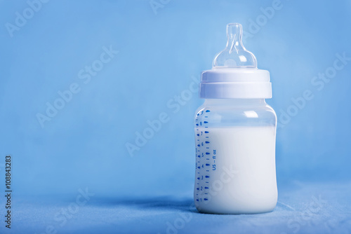Baby milk bottle on a blue sheet