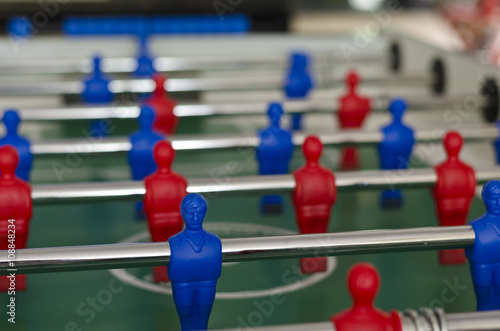 Players of the game of Foosball in red and blue color