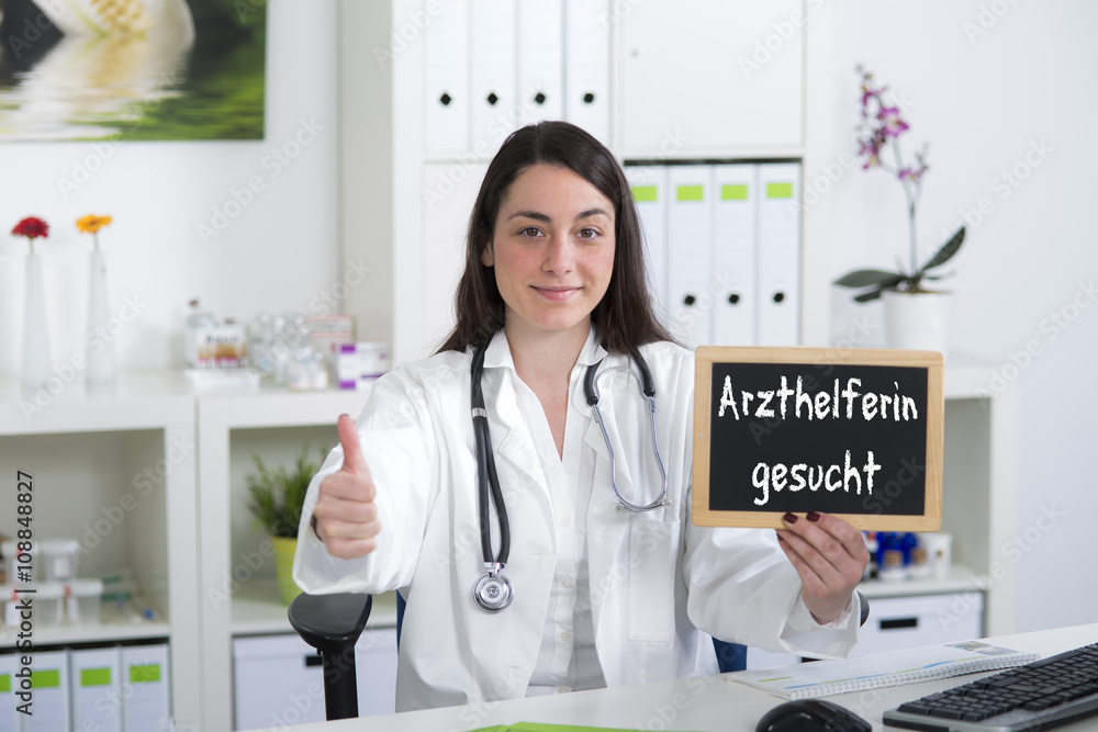 Junge Ärztin bzw. Arzthelferin hält Hinweisschild zur Jobsuche m Junge Ärztin bzw. Arzthelferin hält Hinweisschild zur Jobsuche m