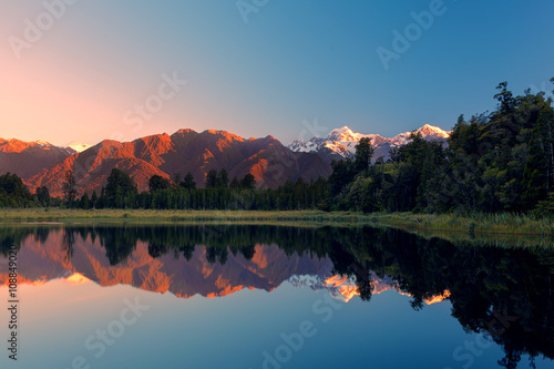Twin Peaks reflect in the beautiful Lake Matheson at sunset, Southern Alps, South Island, New Zealand photo
