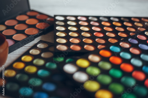 Multicolored eyeshadows on the wooden table
