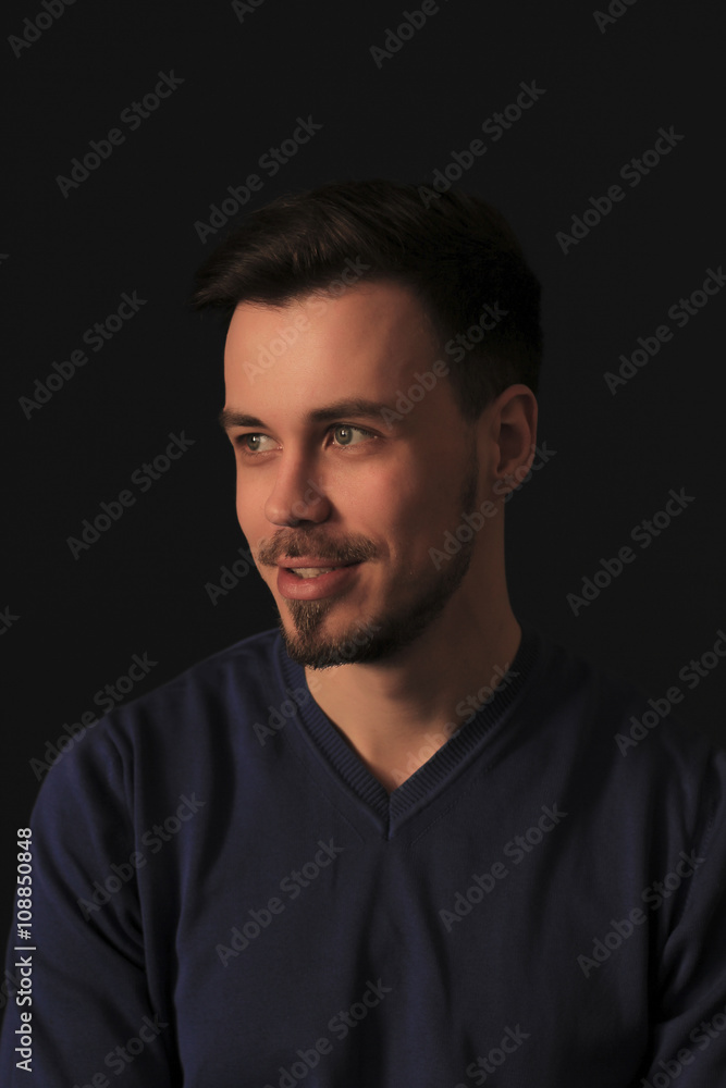 Young brunette man over black wall