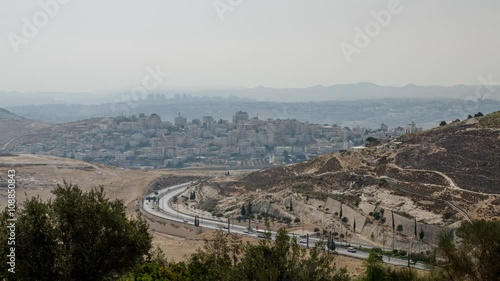 Traffic at Derech Har HaTzofim tunnel road in Jerusalem (Israel) with the town of alZa'im and the haze of the desert at the background. photo