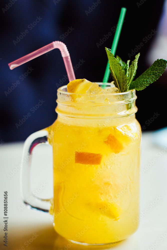 Fototapeta premium Preparation of the lemonade drink with tubes. Lemonade in the jug with lemons with mint on the table