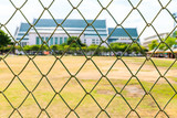 Metal mesh wire fence with blur a football field  background