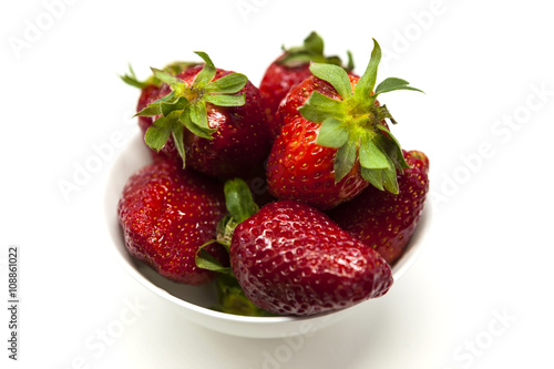 Fresh strawberries on a plate on white background photo
