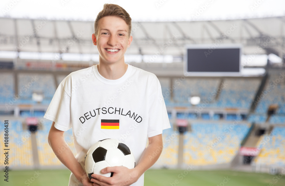 Fototapeta premium Deutscher Fussball Fan mit Ball im Stadion