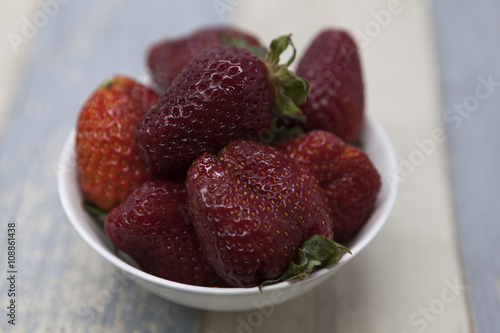 Fresh strawberry on a plate on a blue gray background photo