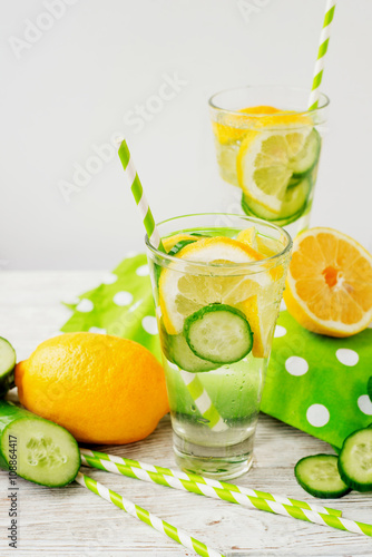 detox , healthy and refreshing drink ,Nutritious cold sparkling water with fresh green cucumber and yellow lemon on a wooden background