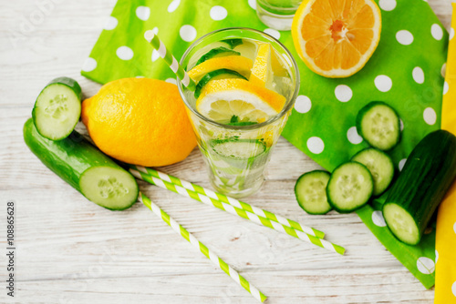 detox , healthy and refreshing drink ,Nutritious cold sparkling water with fresh green cucumber and yellow lemon on a wooden background