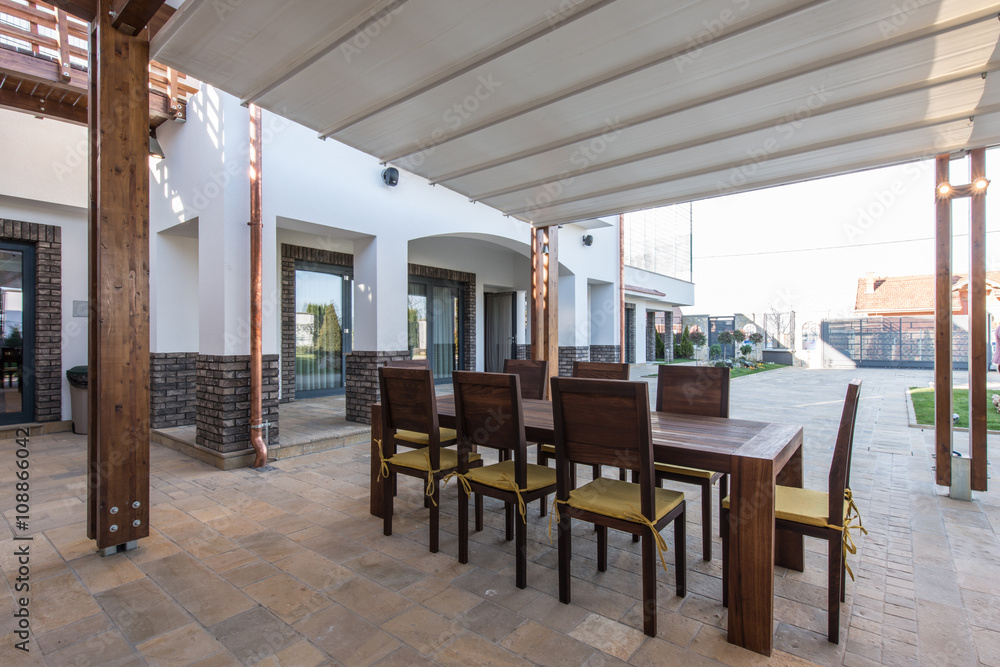 Fototapeta premium Long table and chairs on veranda 