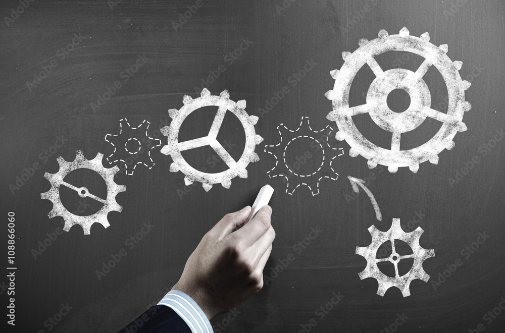 Man drawing gears on blackboard Man drawing gears on blackboard