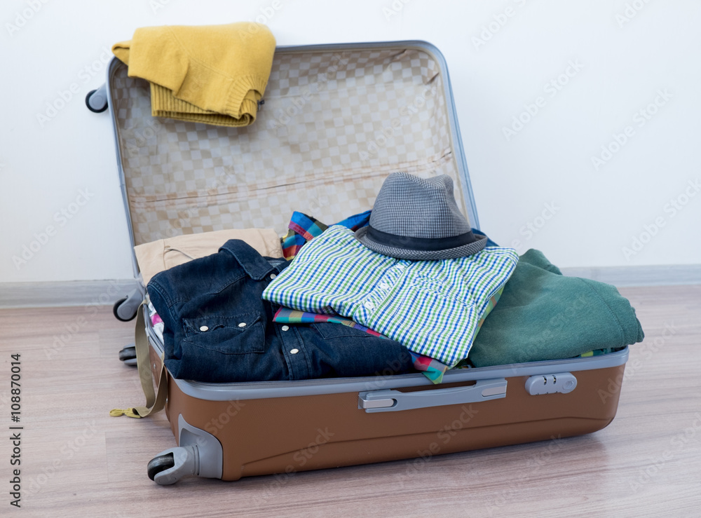 Opened suitcase on floor foto de Stock Adobe Stock