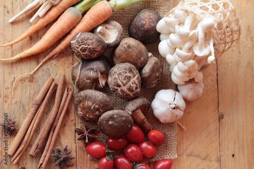 Mushrooms and vegetables on wood background.