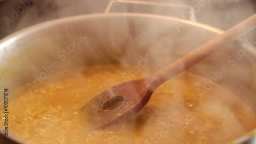 Honey and mustard sweet sour hot sauce boiling in hot pan at stove; close-up; 