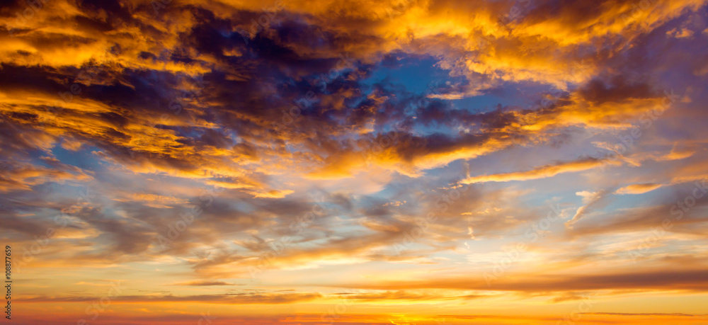 Obraz premium Setting summer sun with fluffy clouds