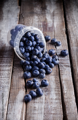 Blueberries in a plastic can on old rustic wooden table