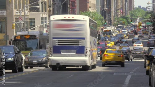 Busy street traffic Manhattan New York City NYC cars buses congested urban sunny day