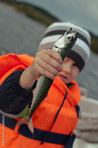 Kid holding his catch in a hand