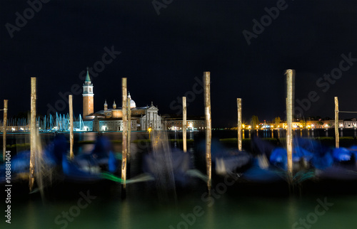 Gondolas anchored on Grand Canal in Venice - long exposure night shot with motion blurred gondolas