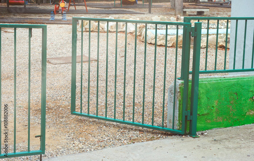 Open gate to playground. Focus is on the ground.
