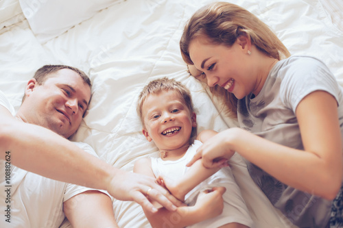 Happy family relaxing in bed