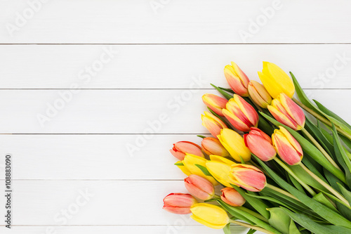 Bouquet of spring tulips on white wooden background. Top view, copy space 
