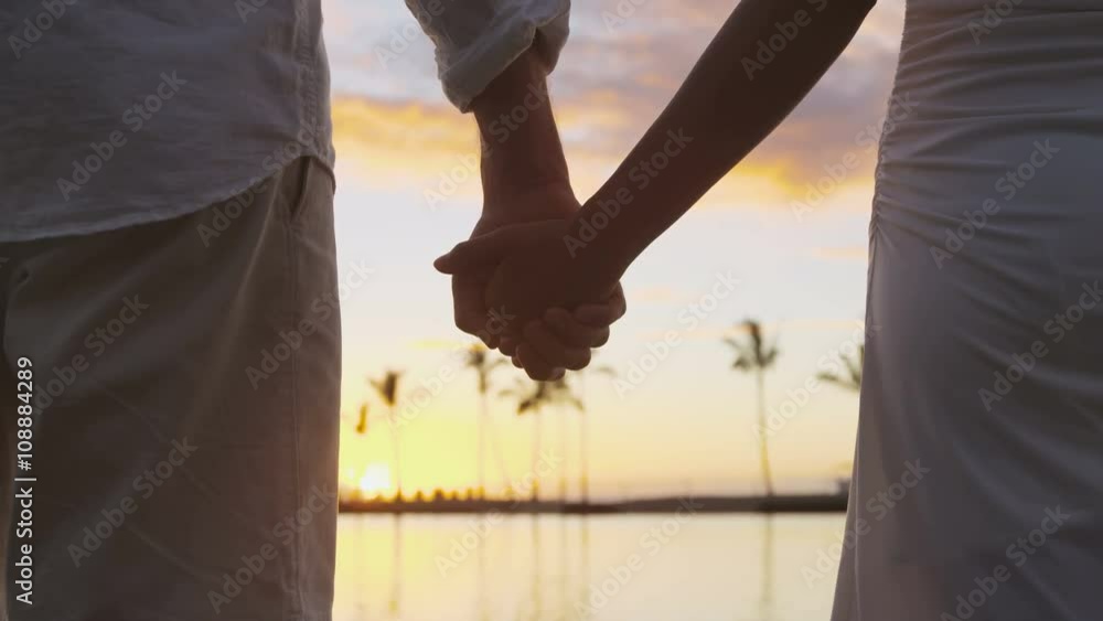 Romantic couple holding hands on beach at sunset Stock Video | Adobe Stock
